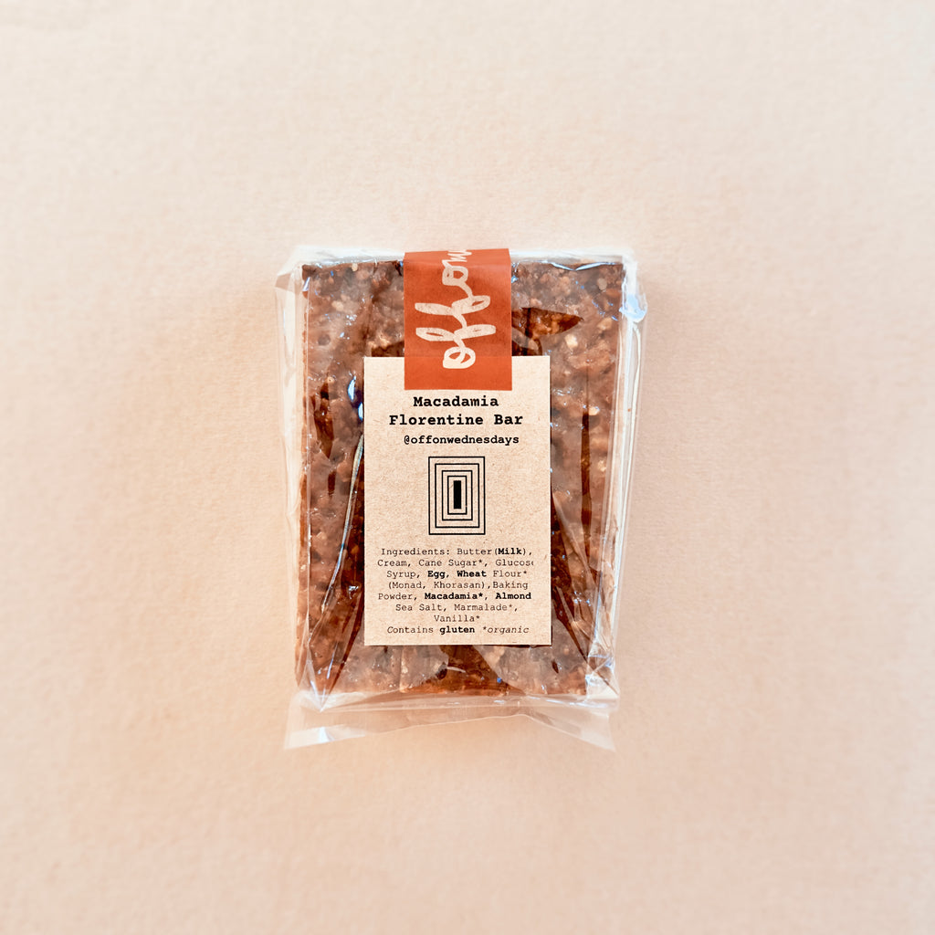 Packaged Macadamia Florentine Bar on a beige background