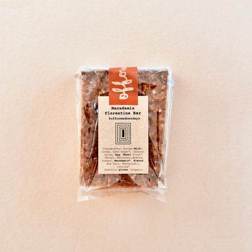 Packaged Macadamia Florentine Bar on a beige background