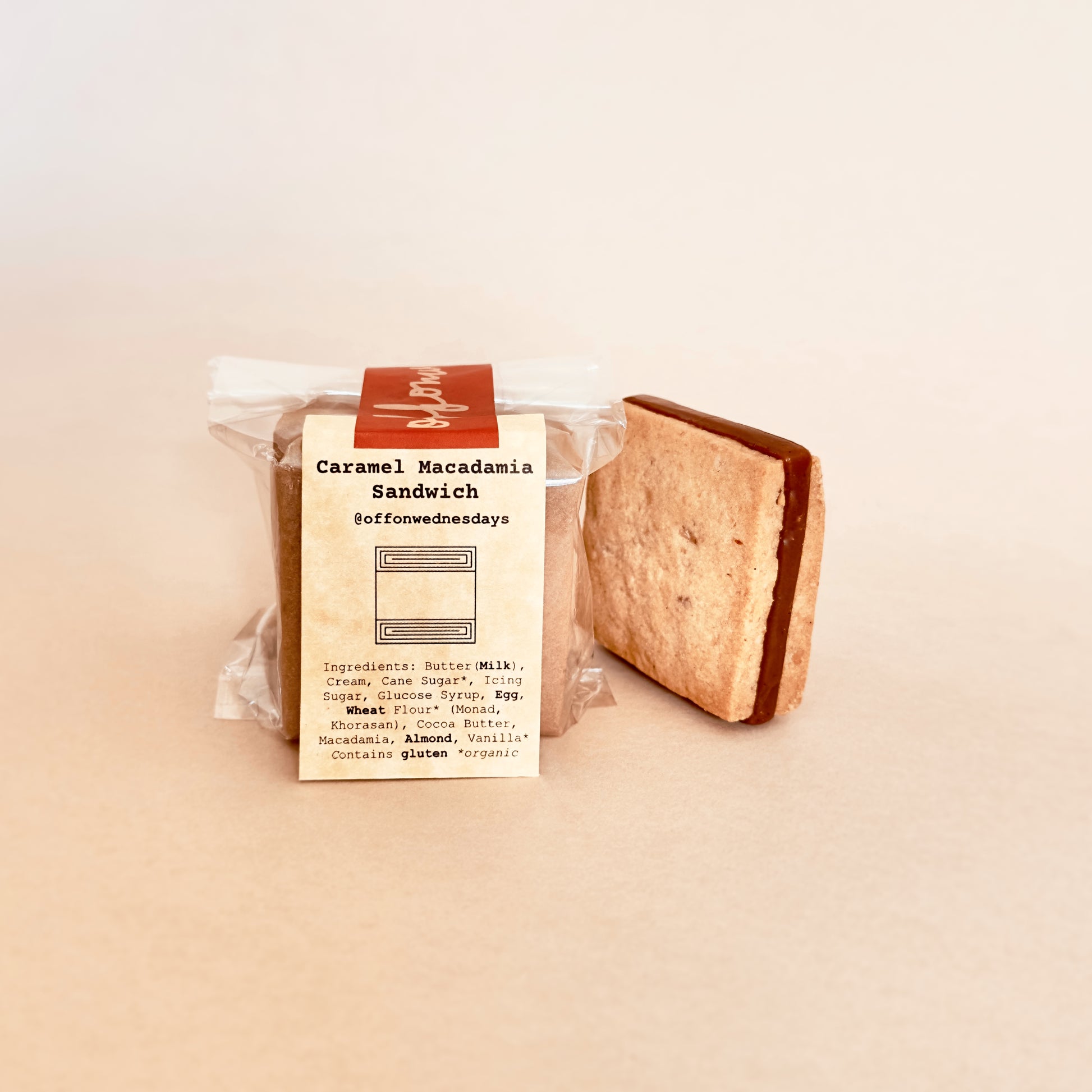 Caramel macadamia sandwich in packaging on a beige background